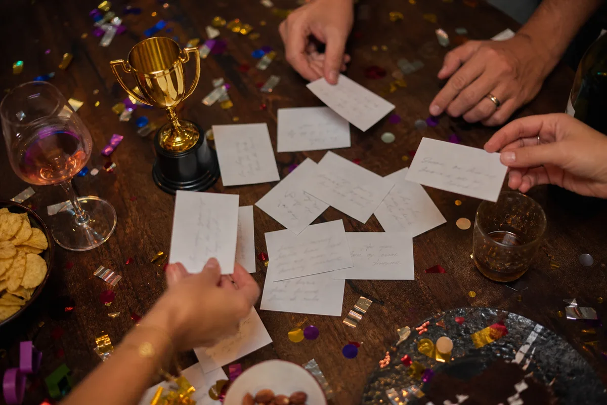Table de soirée avec cartes de défis, trophée et accessoires de fête colorés