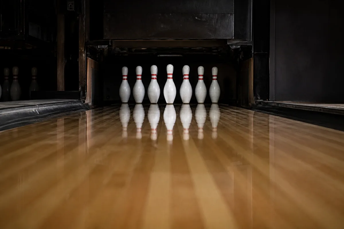 Piste de bowling vide vue depuis la ligne de faute, éclairage rasant sur le vernis